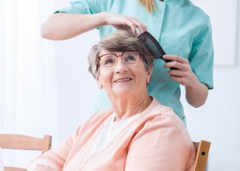 Caregiver doing senior woman's hair