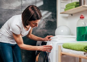 Woman choosing program on washing machine