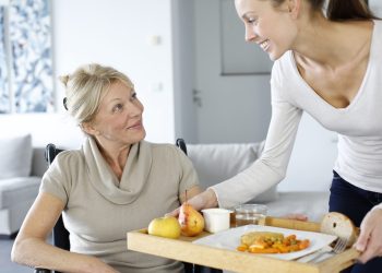 Young woman helping senior woman at home