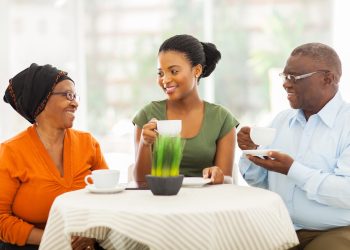 senior african parents having coffee with daughter